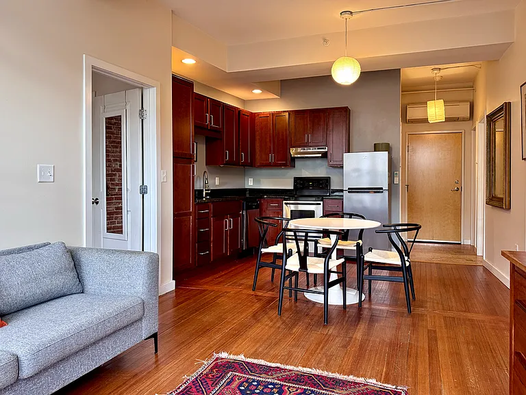Light-filled rooms with tall ceilings. Long view of entry into kitchen/dining area from living room windows.