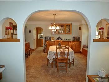 Arched doorway and art alcoves leading into the spacious dining room with window seat and beautiful built-in buffet! NOTE...There are hardwood floors under the carpeting in the dining room, living room and all bedrooms!