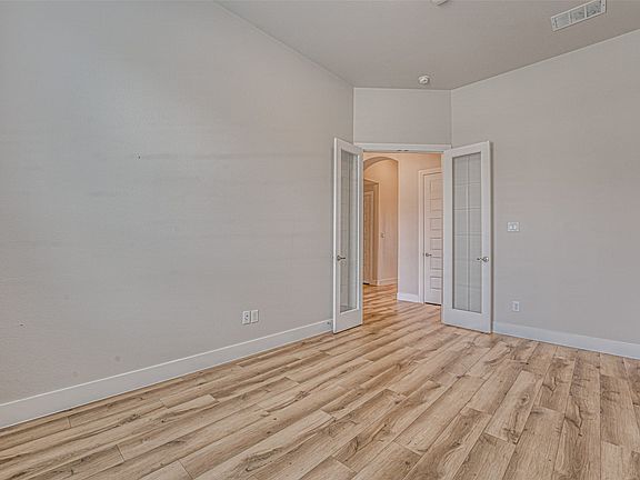 Room featuring wood-finish flooring, neutral wall tones, and white trim