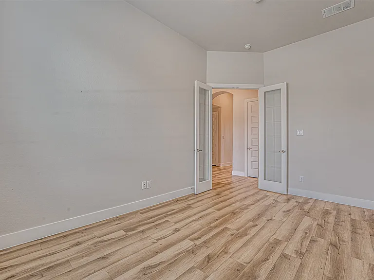 Room featuring wood-finish flooring, neutral wall tones, and white trim