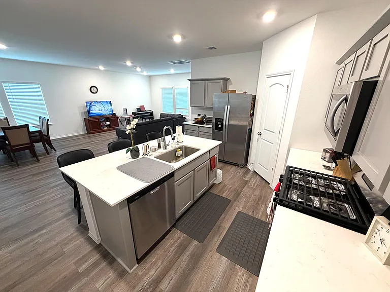 Open-concept kitchen with a large island, bar seating, stainless appliances, and generous counter space for meal prep.