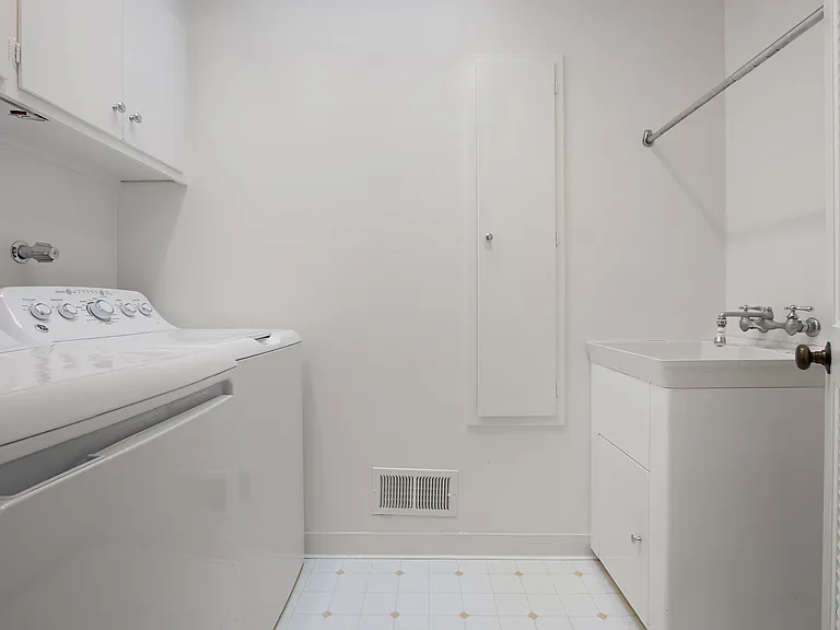 Dedicated laundry room. Washer, dryer, sink, drying rack, storage cabinetry