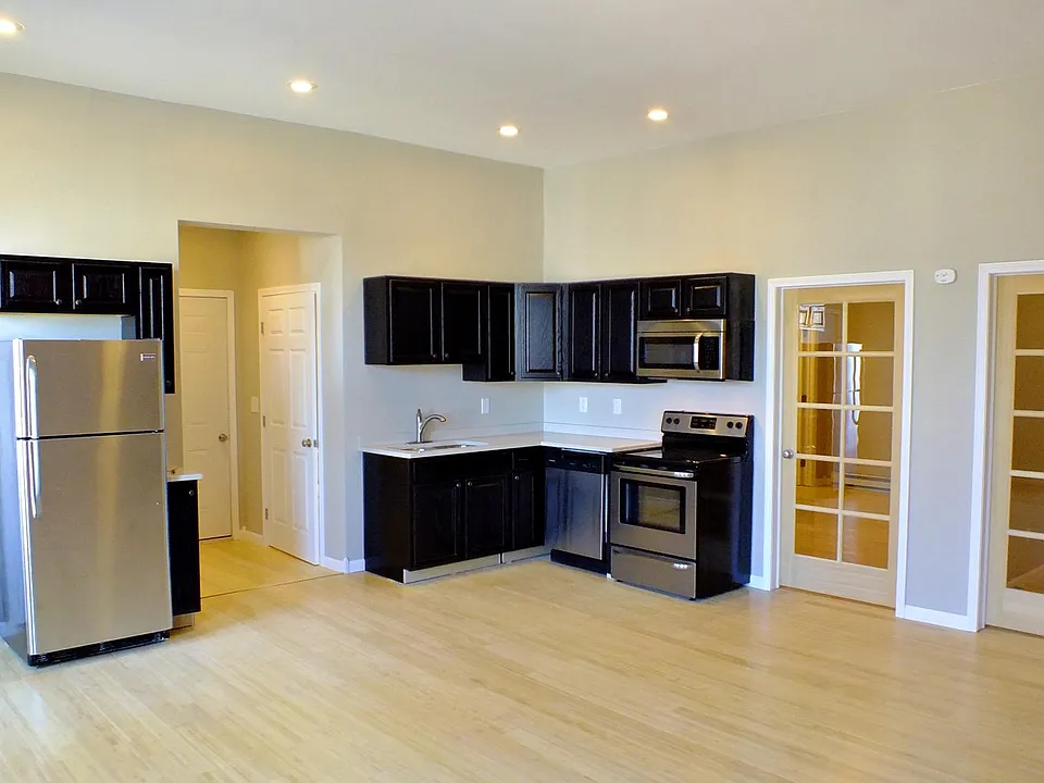 Huge open kitchen and living space with high ceilings and large exposed brick walls