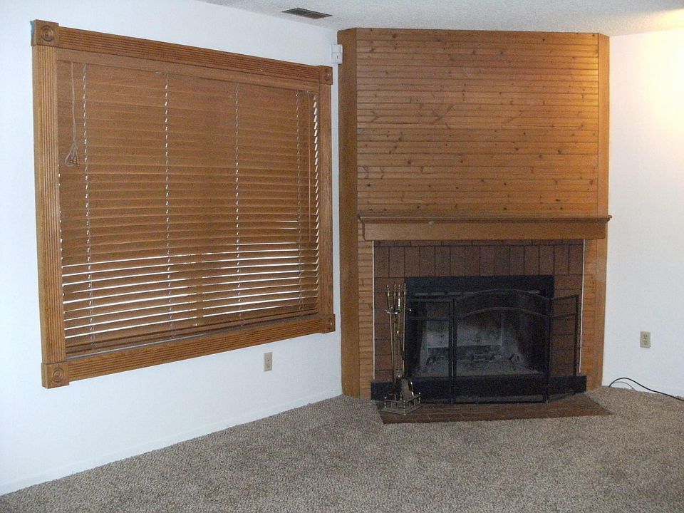 wood burning fire place; flooring is being changed; window has curtain now