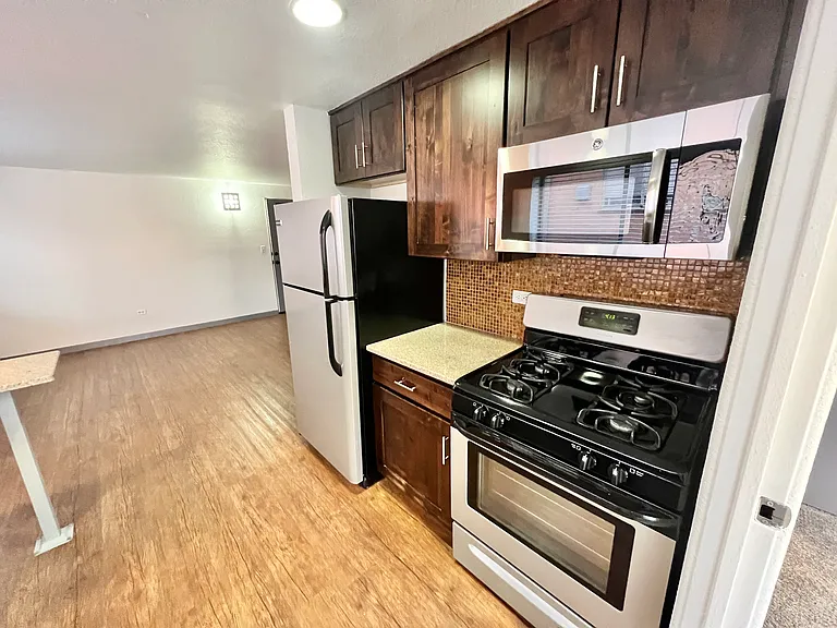 Explore this sleek kitchen equipped with stainless steel appliances and dark wood cabinets. Explore this sleek kitchen equipped with stainless steel appliances and dark wood cabinets.