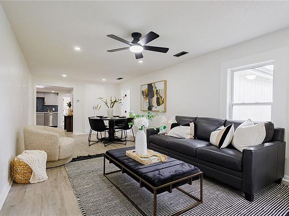 Open-concept living space featuring wood-finish flooring, recessed lighting, and a modern ceiling fan