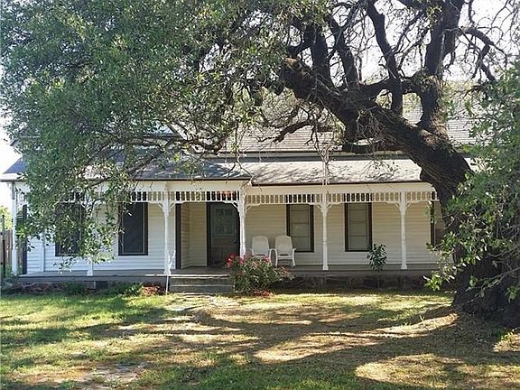 Home sits off the road with  large oak tree in front with new front porch