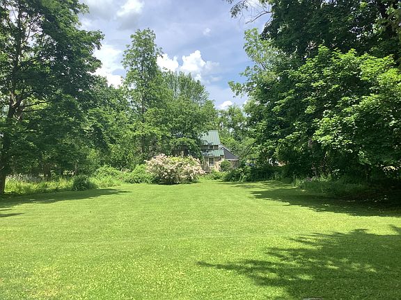 Back yard, to neighboring cottage. The yard perimeter has thick foliage & privacy from neighbors. It gently slopes down.