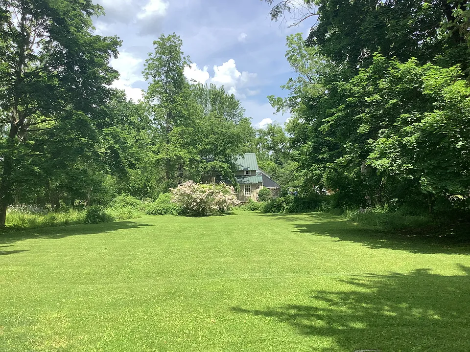 Back yard, to neighboring cottage. The yard perimeter has thick foliage & privacy from neighbors. It gently slopes down.