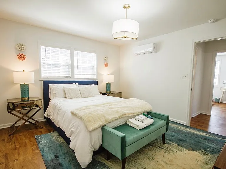 One of three bedrooms equipped with a queen sized bed and furnished stylishly.