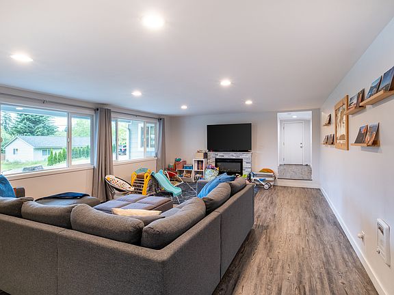 The living room boasts a cozy fireplace, elegant luxury vinyl plank flooring, and large windows that flood the space with natural light.