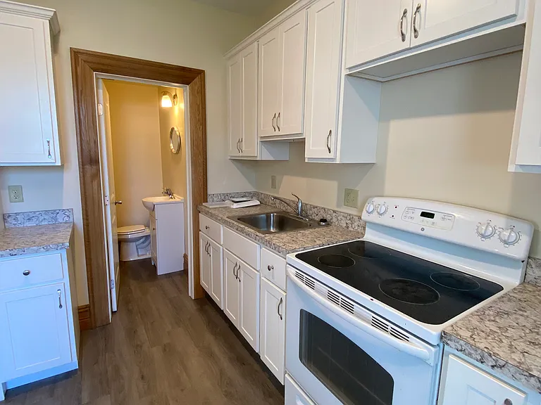 Kitchen space looking into entrance of bathroom