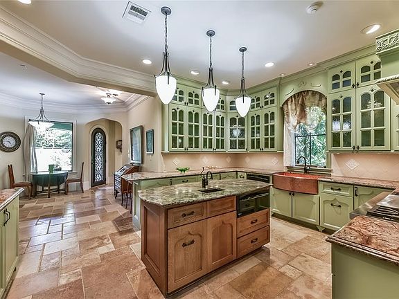 Formal dining room with Tiger Oak hardwood floors, Swarovski crystal chandelier and sconces, elliptical ceiling w/ light is just off the entry. Beautiful casement windows are framed with stained wood and offer views of the manicured front yard.