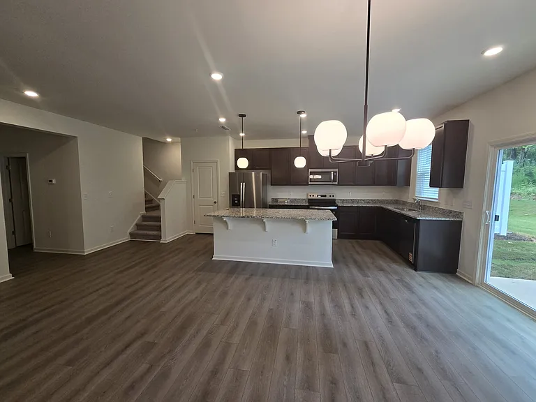 View of the 1st floor from living room. Look at the depth of the room with full visibility of kitchen and stairs to 2nd floor