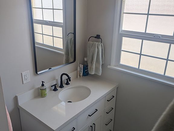 Full bathroom with shower and tub, along with new vanity/mirror/lighting, new toilet, and new bathroom fan.