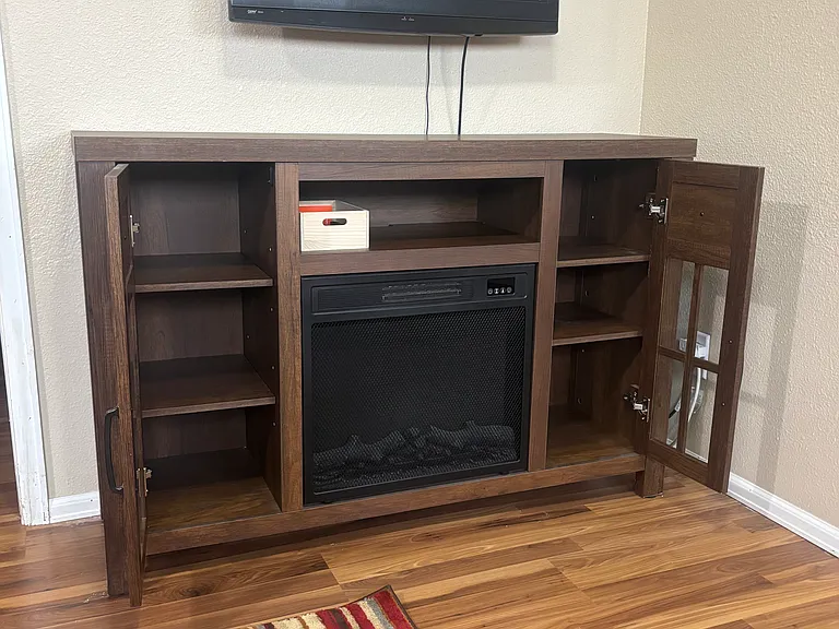 Electric fireplace has enclosed bookshelves or storage.