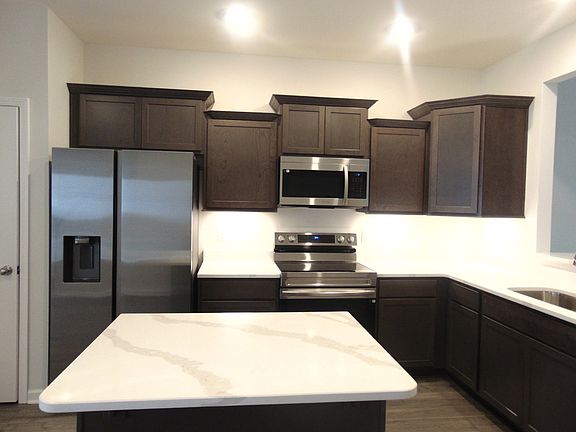 The kitchen is spacious and modern, it comes with steel appliances, and crown cabinetry for a uniqu