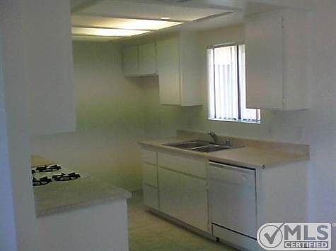 Kitchen has tile and white appliances.