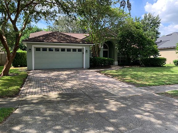Driveway with brick pavers leading to two-car garage