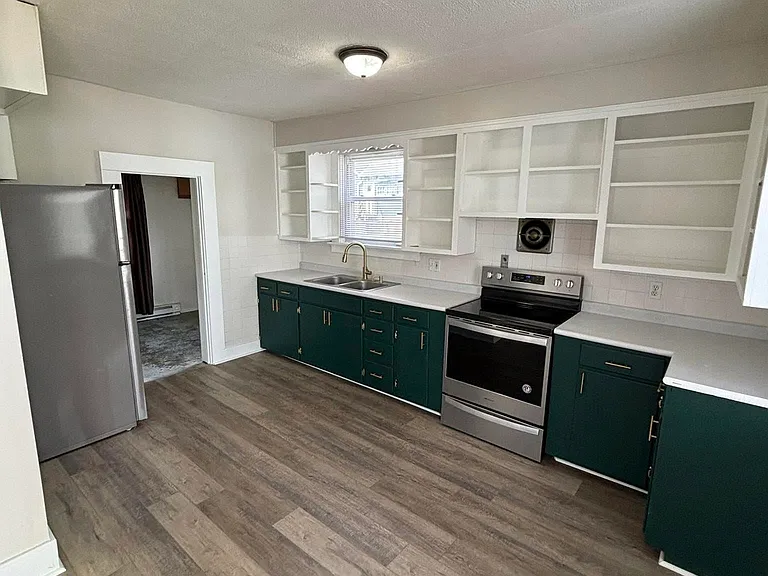 Entrance to laundry room seen next to fridge