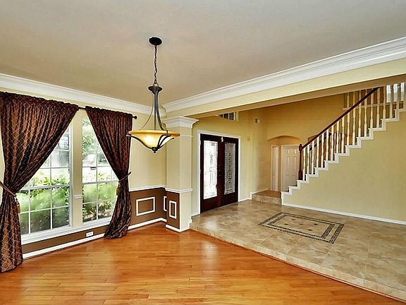   View from the formal dining room with rare diagonal laid hardwood floor, accent paint and custom drapery