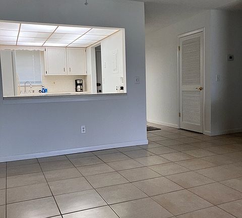 Open view of the dining room, kitchen, and entryway.