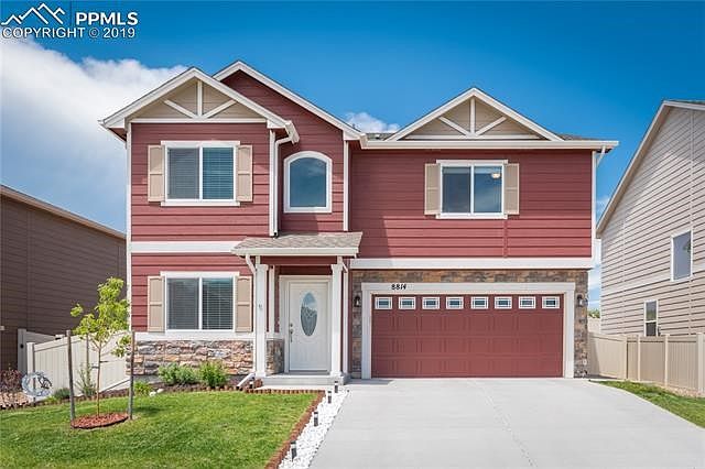 Gorgeous landscaping with cedar plank and solar light boarder. Note the decorative front and garage doors.