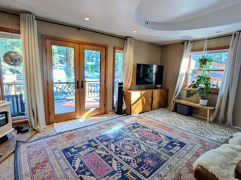 Primary bedroom with ensuite, walk-in closet, king bed, private deck, and gas fireplace