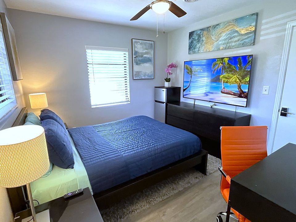 Room 2 features: Queen bed, dual night stands, table lamps, ceiling fan, mini fridge, desk, 65in TV