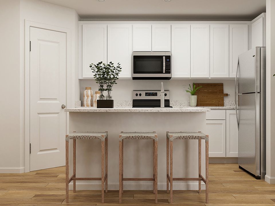 The kitchen of the Delano has beautiful white wood cabinetry and sprawling granite countertops.