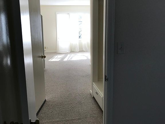 Hallway from bedroom looking to living room. Hall closet for coats and shelving for supplies!