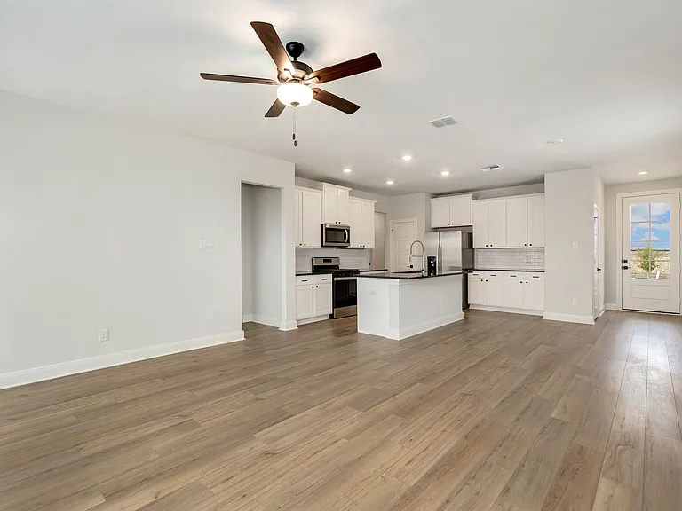 A spacious open plan with vinyl flooring.
