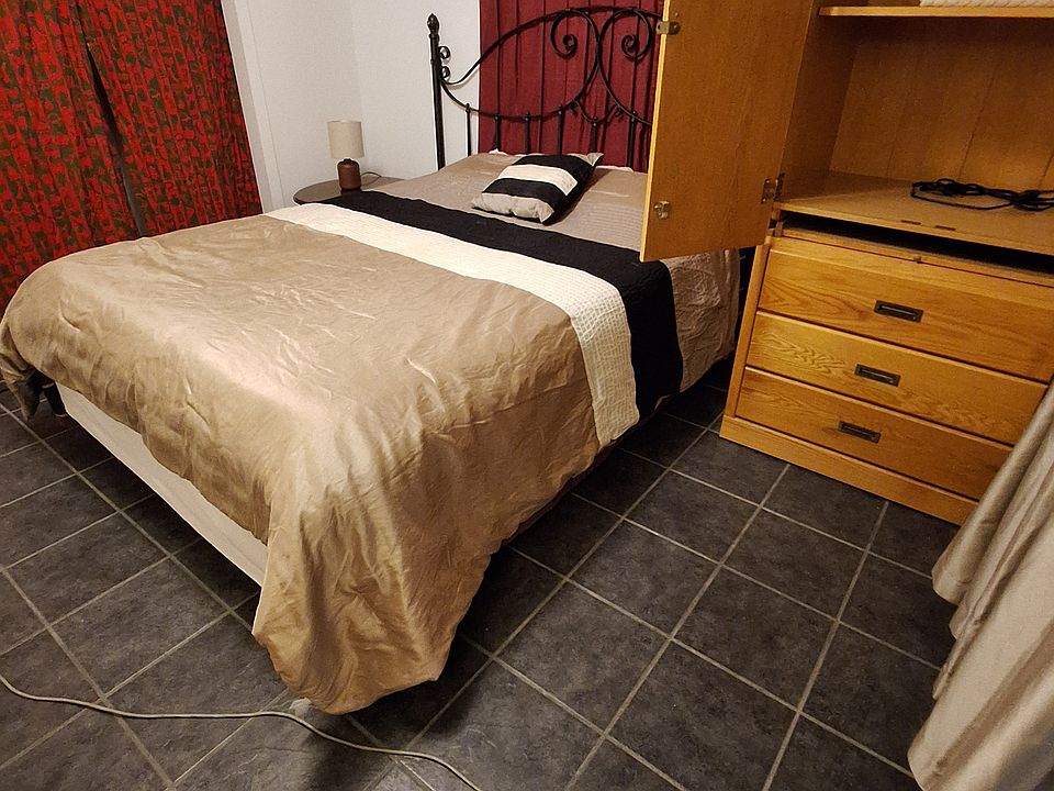 bedroom w queen bed furnished 
with clothing chest of drawers