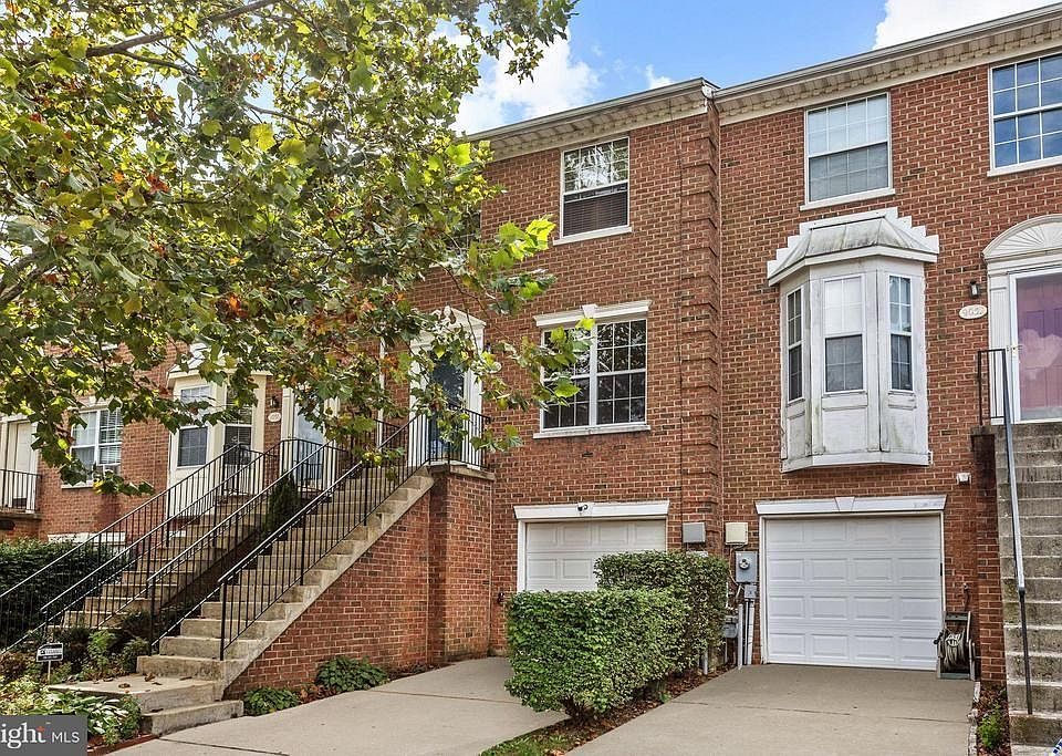 Brick exterior townhome with garage and driveway.