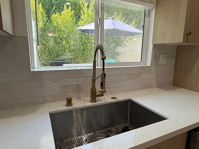 Large kitchen window with greenery view.