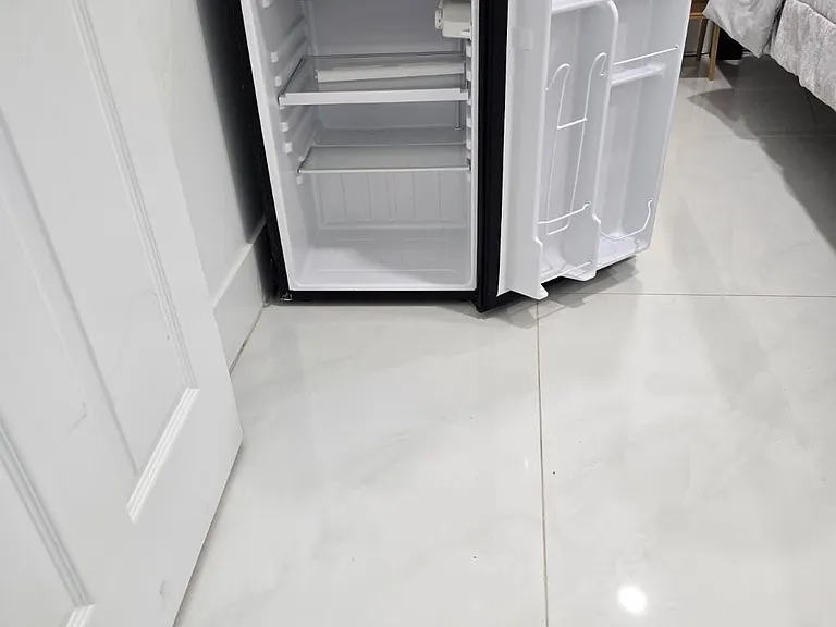 In-room mini fridge provides convenient storage for drinks and snacks, adding everyday ease for residents.