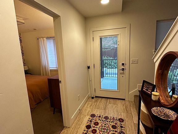 The entry hall, with a bedroom off to the left and the stairs to the right which leads to the main living space