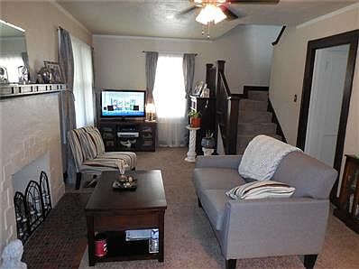 Newly carpeted living room with hardwoods underneath spans the entire front of the home.