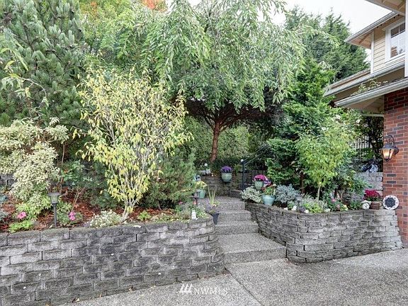 Beautifully landscaped yard that has been terraced with a grand garden wall.