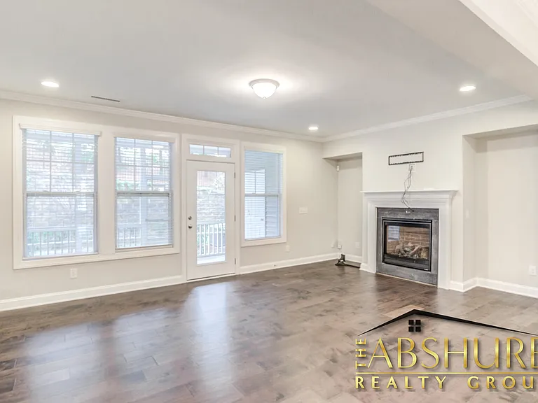 Open concept living room with crown molding, gas fireplace and energy efficient recessed lighting
