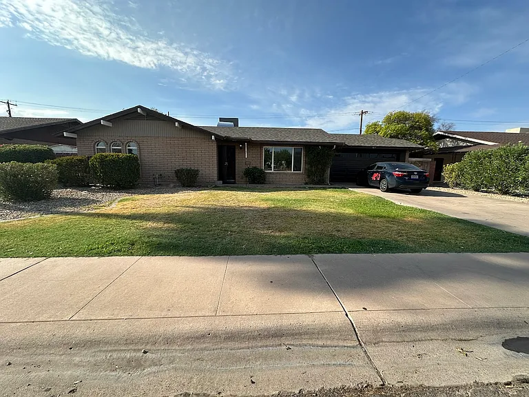 Grass and landscaped front yard with 2-car garage, driveway parking, and additional street parking