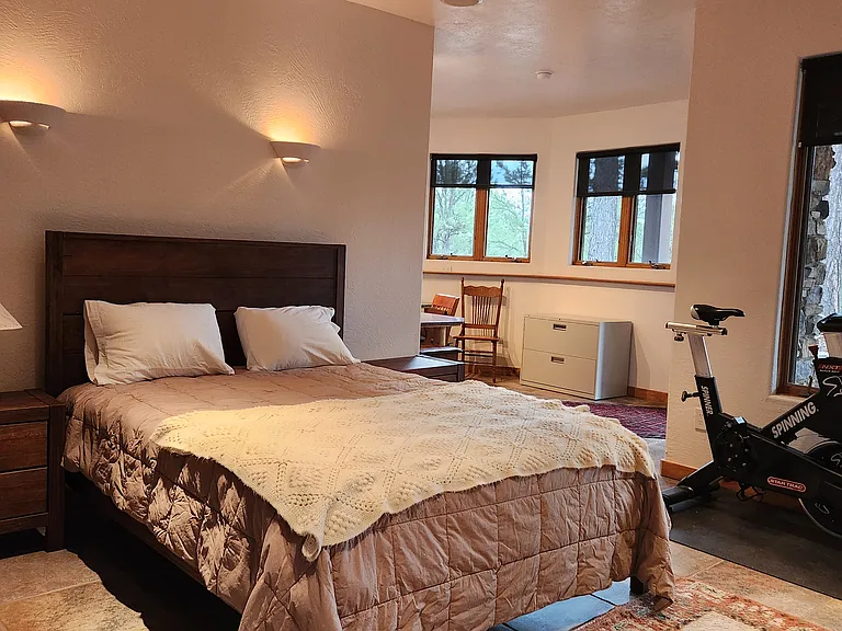Large bedroom downstairs with queen size bed, looking to office area