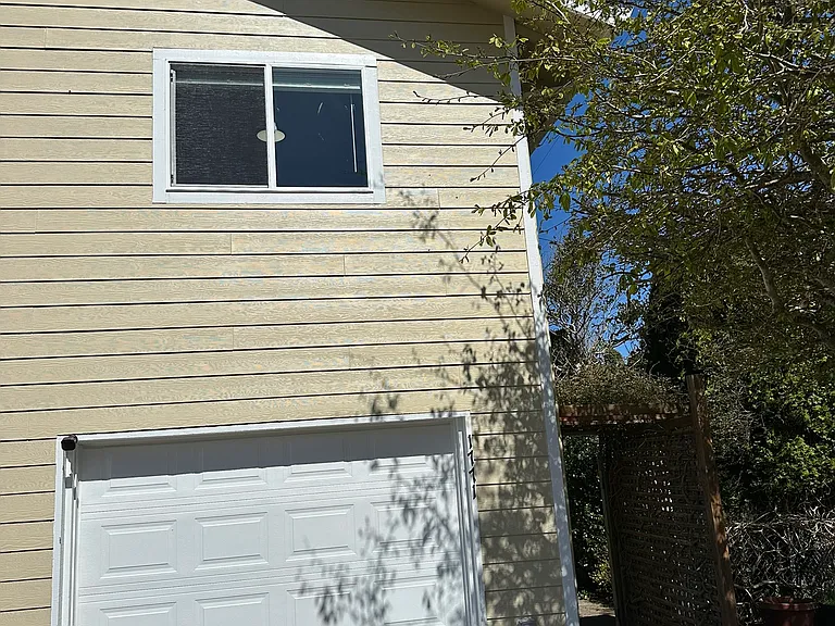 Downstair one car garage with ample space on the driveway for another car, house in on the second level