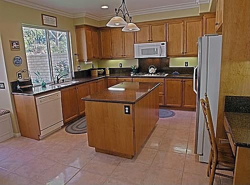 Spacious kitchen with quartz counters and maple cabinets.