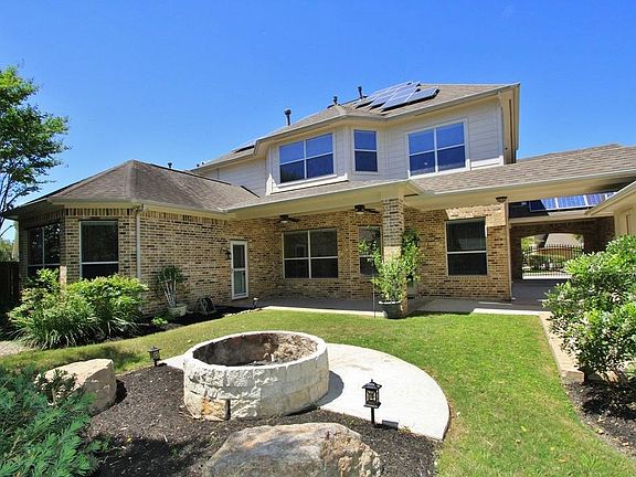 Here's the Back of the Home showing off the built-in fire pit and the Covered Patio.