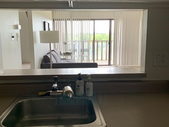 View from kitchen sink to living space and balcony. Notice new dishwasher. Unit faces east. Beautiful sunrises.