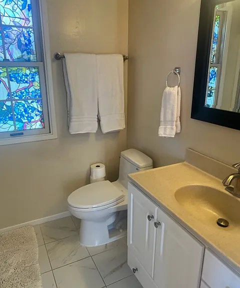Bathroom with window, vanity and mirror