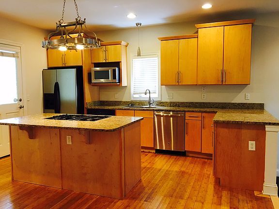 Large kitchen with gas cooktop, microwave, oven, fridge. Al