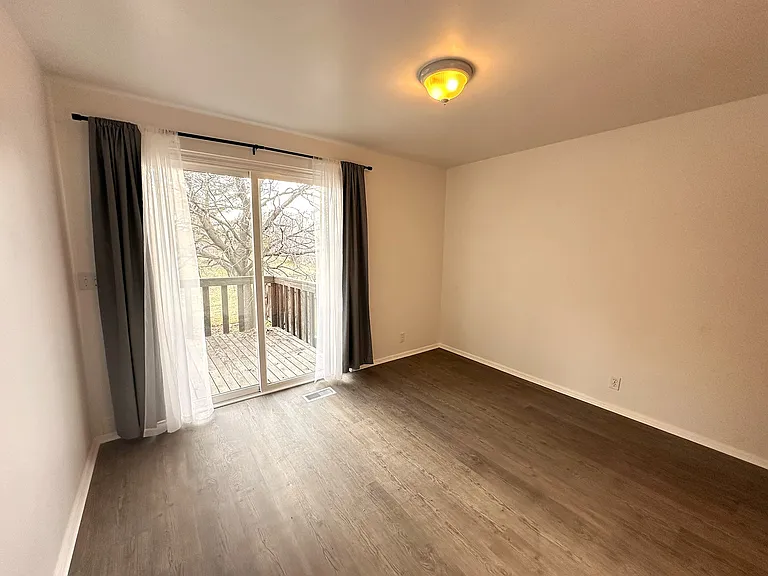 Main Floor Bedroom #2 with Sliding Door to Backyard Deck & View