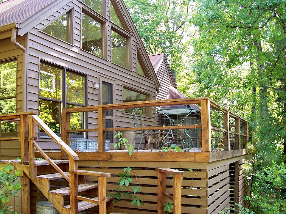 Nestled in the woods, this home is oriented toward the trees (rear view shown)